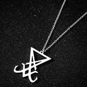 Vue macro du pendentif Sceau de Lucifer en acier inoxydable sur fond texturé noir