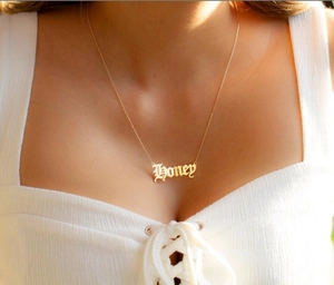 Close-up of gothic Honey letter pendant necklace on model with golden finish