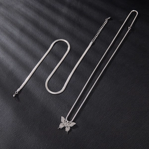 Dettaglio della collana a doppio strato d'argento con ciondolo a farfalla su fondo pelle