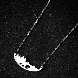 Vue détaillée du pendentif avec silhouettes de montagne et d'ours sur une chaîne argentée