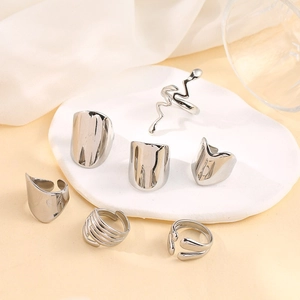 Close-up of a 6-piece silver stainless steel twisted and geometric ring set on a tray