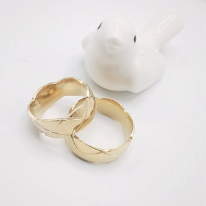 Close-up of golden stainless steel rings featuring classic quilted diamond patterns