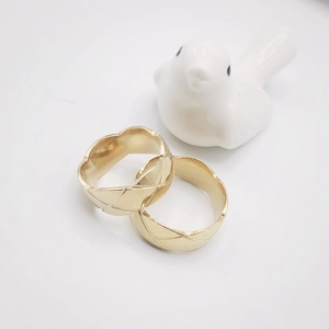 Macro view of wide golden stainless steel rings with cross-quilted diamond pattern