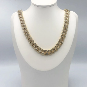 Dettaglio collana a maglia cubana dorata con strass incastonati su un busto da esposizione