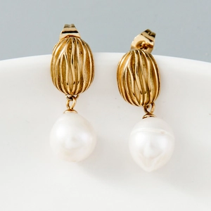 Detailed view of vintage gold textured stud earring with elegant white pearl drop