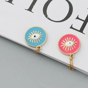 Dettaglio dei ciondoli occhio del male in smalto blu e rosa su catenine dorate a maglie