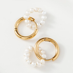 Détail de boucles d'oreilles créoles dorées style vintage avec perles d'eau douce amovibles