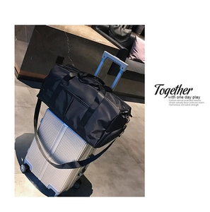 Large black fitness travel bag with luggage sleeve attachment on a silver suitcase