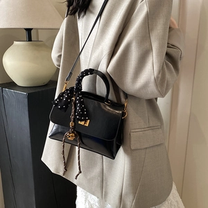Classic black leather crossbody bag with polka dot scarf and golden metal hardware