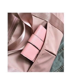 Detailed close-up of pink nylon gym bag side pocket and matching leather wallet texture