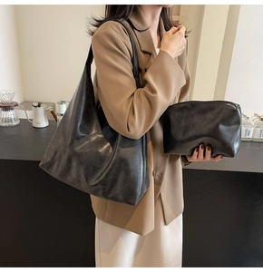 Detail of minimalist black PU leather tote bag with a matching small zipper pouch