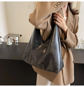 Close-up of dark grey textured leather tote bag with geometric layered design detail