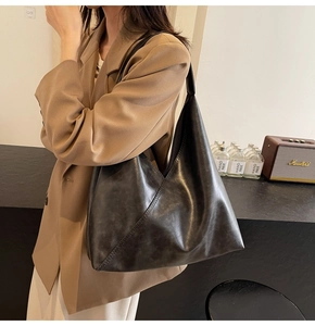 Detail of vintage black oil wax leather tote bag with unique triangular silhouette design