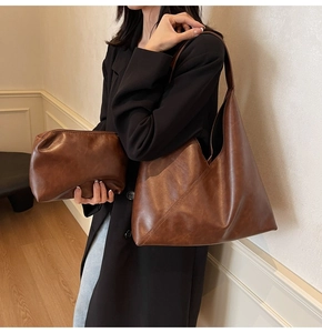 Detail view of vintage brown leather tote bag with matching zippered cosmetic pouch