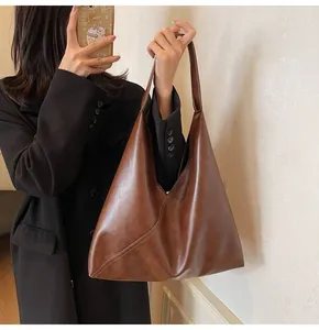 Detail of soft brown leather tote showing diagonal stitching and minimalist vintage style