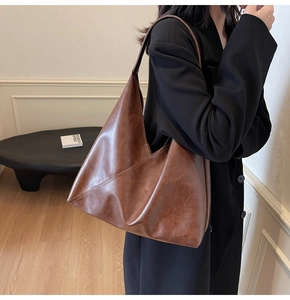 Close-up of vintage brown hobo bag showing retro soft leather texture and sewing details