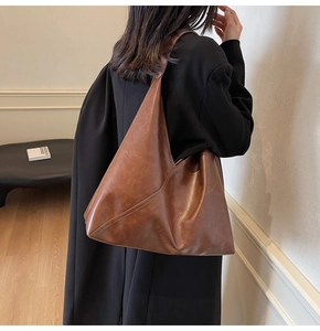 Detail view of large brown shoulder tote bag with vintage oil wax leather texture