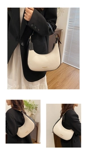 Detail of beige lychee pattern hobo bag with black trim and gold brand logo