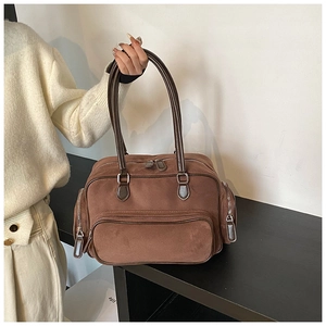 Detail of vintage brown suede shoulder bag with functional zippers and retro bowling shape