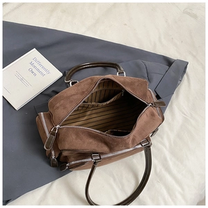 Internal view of brown suede tote bag with striped lining and multiple zipper compartments