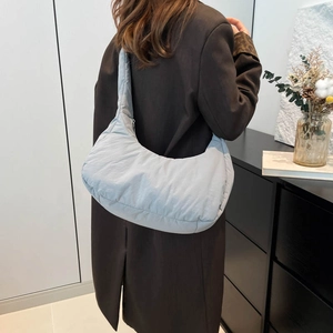 Quilted light blue oversized tote bag for women shown as a shoulder bag on a model