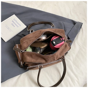 Spacious dark brown suede Boston bag interior showing phone, tumbler, and cosmetics