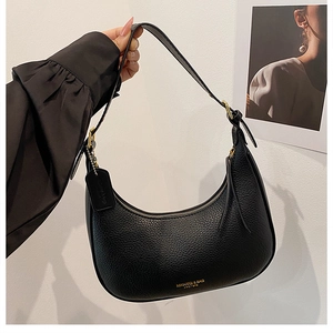 Detail of black pebbled leather crescent bag with gold zipper and adjustable buckle
