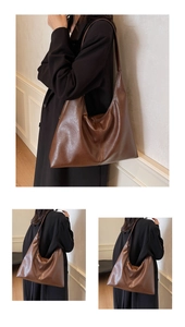 Close-up detail of a large brown hobo tote bag featuring premium pebble leather texture