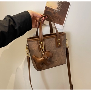 Retro brown bucket bag with canvas stitching and metal balloon dog charm detail