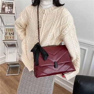 Quilted wine red chain shoulder bag with black ribbon charm and matte leather texture