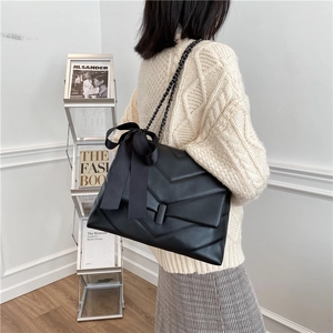 Black quilted leather crossbody bag with chain strap and large bow decoration for women