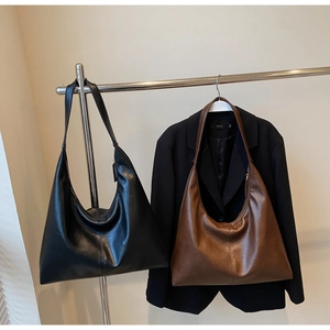 Detail view of large minimalist tote bags in black and brown soft leather textures