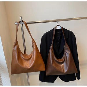 Detail view of two large vintage tote bags in brown and coffee faux leather finish