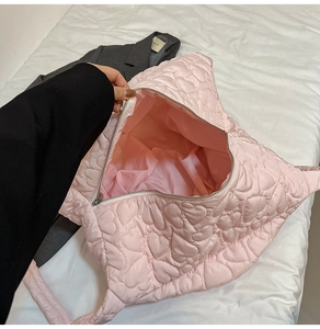 Detailed macro view of pink heart-quilted nylon tote with large capacity and zip closure