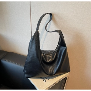 Detailed side view of a large black faux leather hobo bag with zipper and soft texture