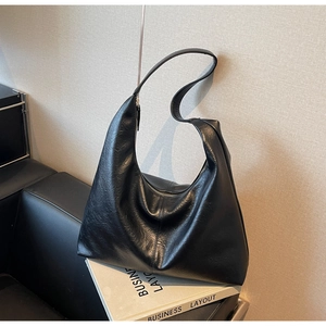 Close-up of black soft PU leather hobo bag with smooth metal zipper and pleated texture