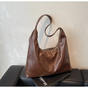 Detail of soft brown leather tote bag with vintage texture and vertical stitching