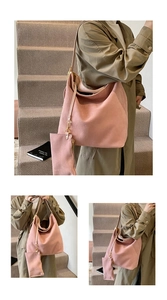 Detail of pink suede tote bag featuring large capacity and matching small pouch bag