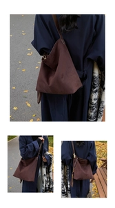 Detailed close-up of dark brown suede tote bag with zipper and slim shoulder straps