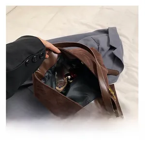Detailed view of dark brown suede tote interior showing spacious storage for cosmetics