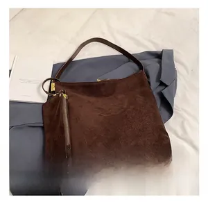Detail of dark brown frosted suede tote bag with metal zipper and gold hardware