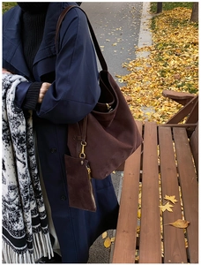 Détail d'un grand sac cabas en daim marron foncé avec pochette zippée en décor d'automne