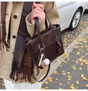 Borsa a secchiello marrone vintage con dettagli in metallo e ciondoli in un set autunnale