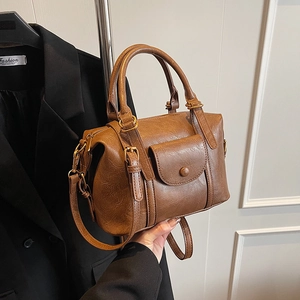 Chic brown leather pillow crossbody bag with top handles and a vintage flap pocket