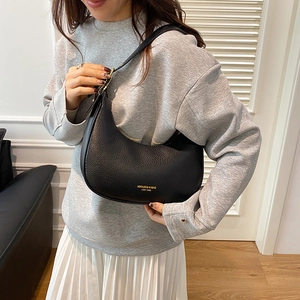 Retro black hobo shoulder bag with litchi texture and gold logo on female model