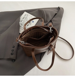 Vista dall'alto dell'interno della borsa in pelle marrone con fodera e tasca zip