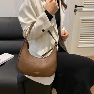 Retro brown lychee leather dumpling bag worn as a shoulder bag by a model