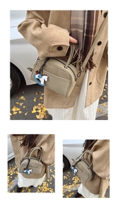 Detail of matte khaki bowling bag with cute horse charm in autumnal street setting