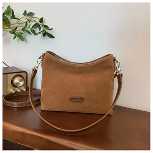 Makro-Detail der braunen matten Ledershopper-Tasche mit Vintage-Textur und Metallhaken