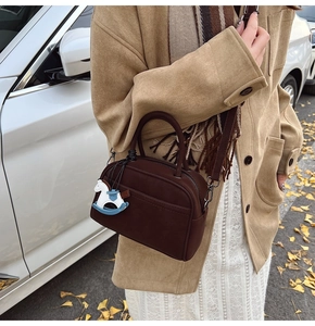 Brown frosted leather bowling bag with horse charm shown in an autumn street setting